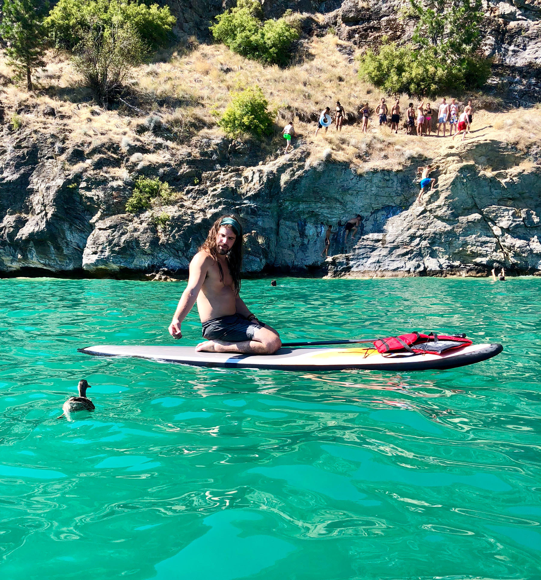 L’homme qui lance cette invitation, assis sur une planche à pagaie